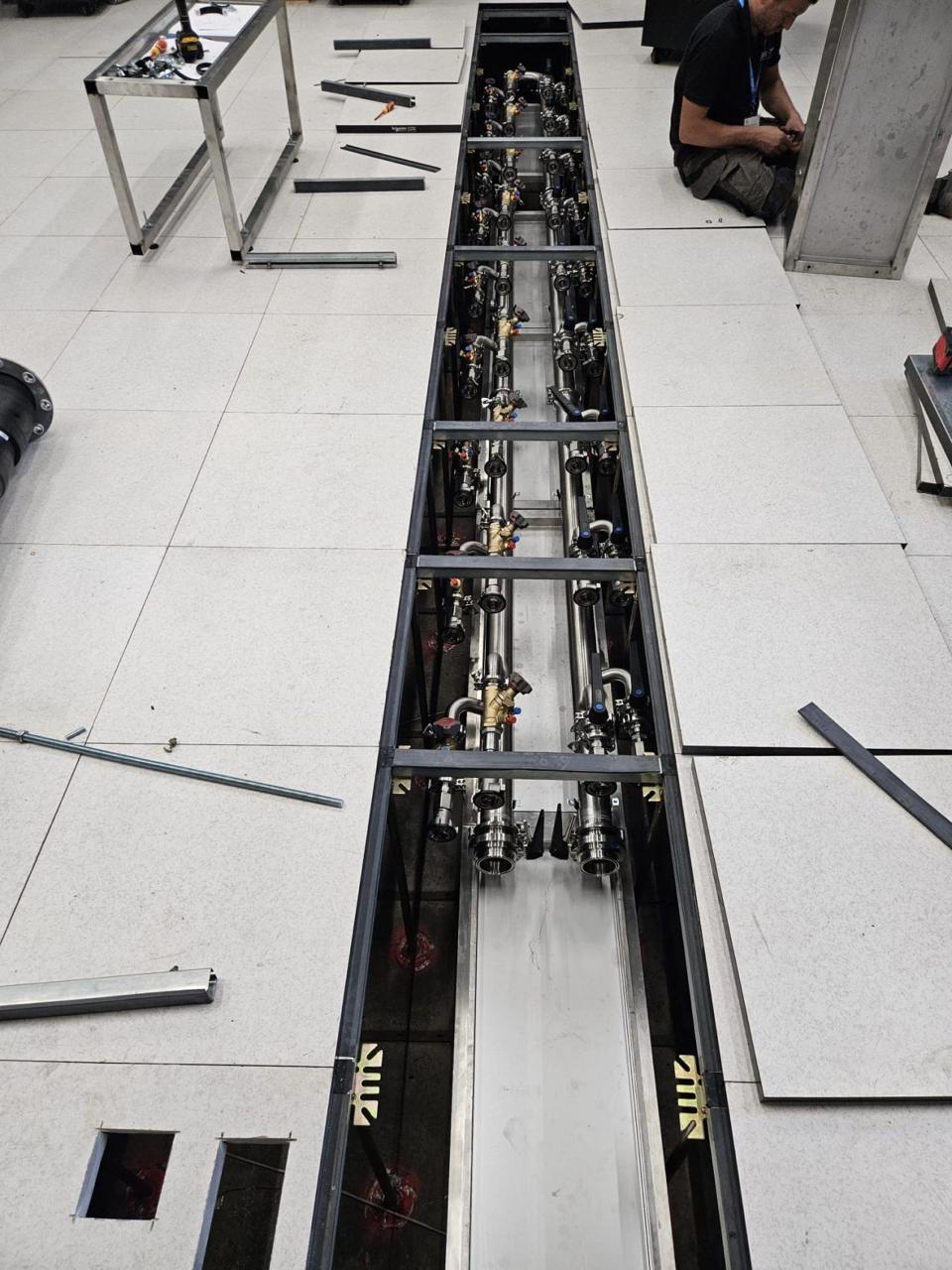 Cooling manifold being installed inside a raised-floor trench during commissioning